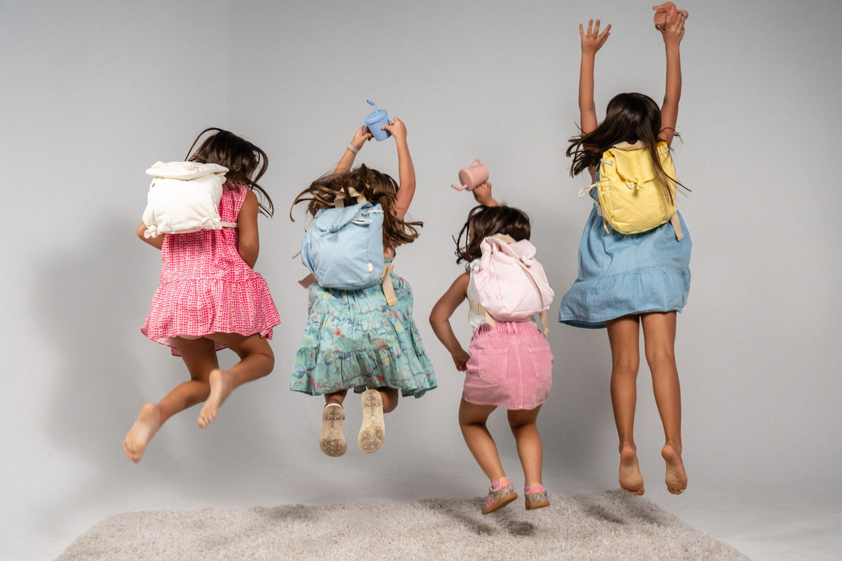 Four kids jumping with their Emilio backpacks